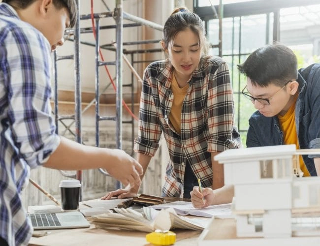 group smart asian architect interior design team consulting with constrction engineer work brainstrom meeting with house project blueprint home mockup house renovation structure background